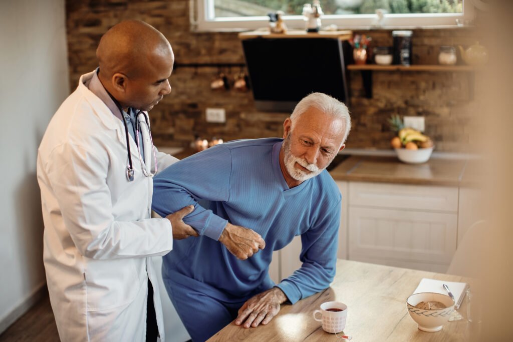 Elderly patient receiving home physiotherapy support for back pain and mobility recovery